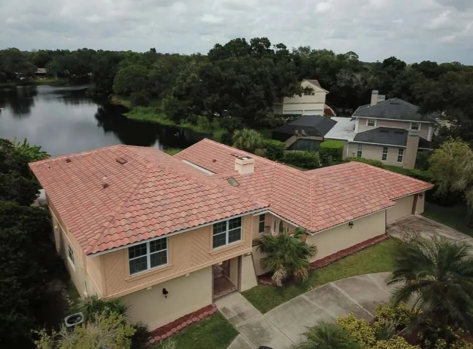 Tile roof on a two-story home beside a lake