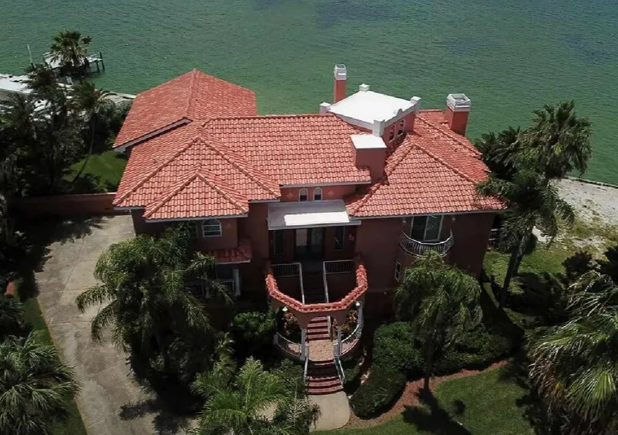 Drone view of a waterfront Tampa Bay home with a finished terracotta tile roof